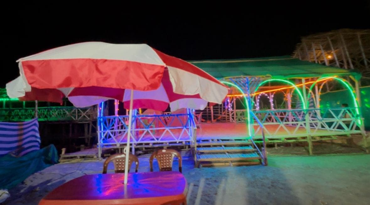 Outdoor seating and a lit pavilion at night
